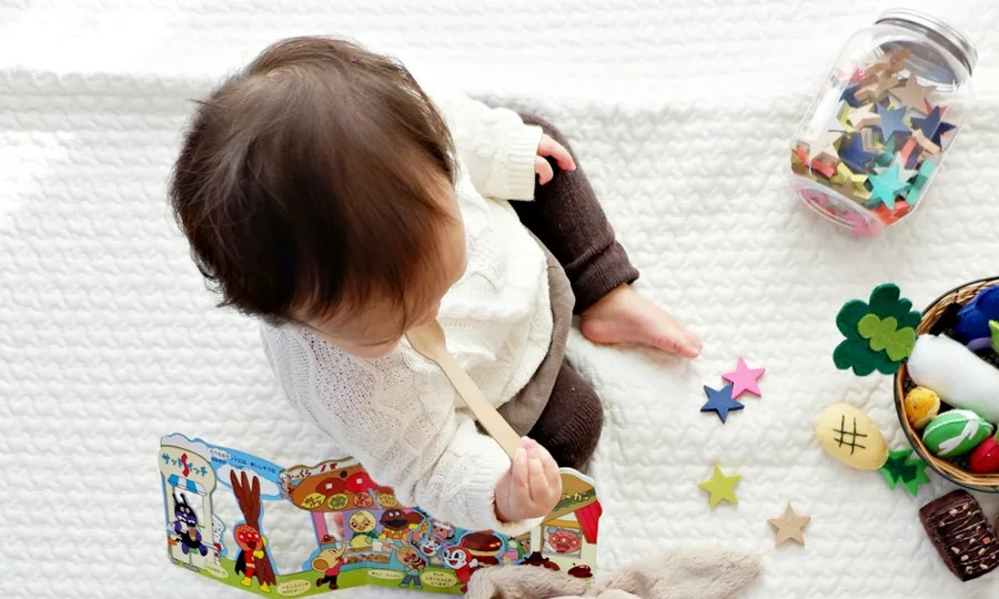 Un niño pequeño sentado en el piso, jugando entre sus juguetes